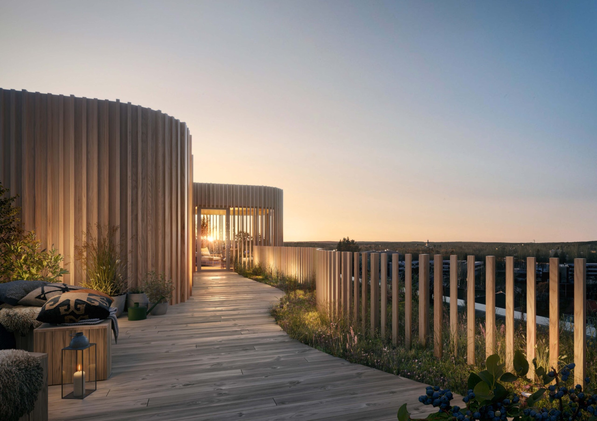Rooftop terrace at Karlavagnen — corporate housing in Skellefteå from Guestly Homes Shared rooftop terrace at Karlavagnen in Skellefteå at sunset, with timber decking, planted beds and a view over the city